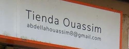 El letrero blanco de la fachada con el nombre «Tienda Ouassim» y el correo de la tienda