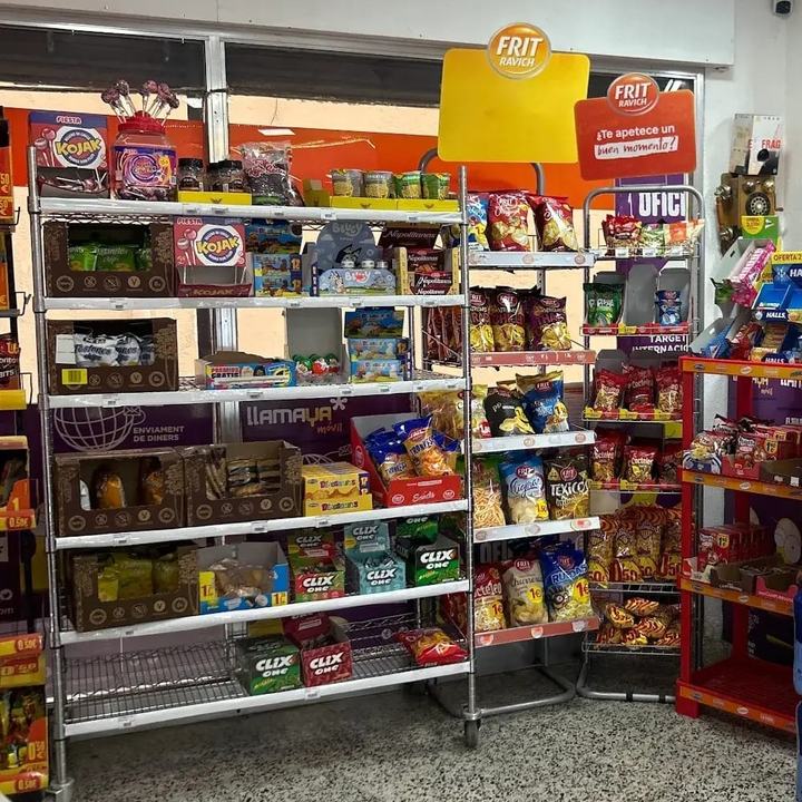 Estanterías de Tienda Ouassim con bolsas de patatas, snacks, chicles y caramelos